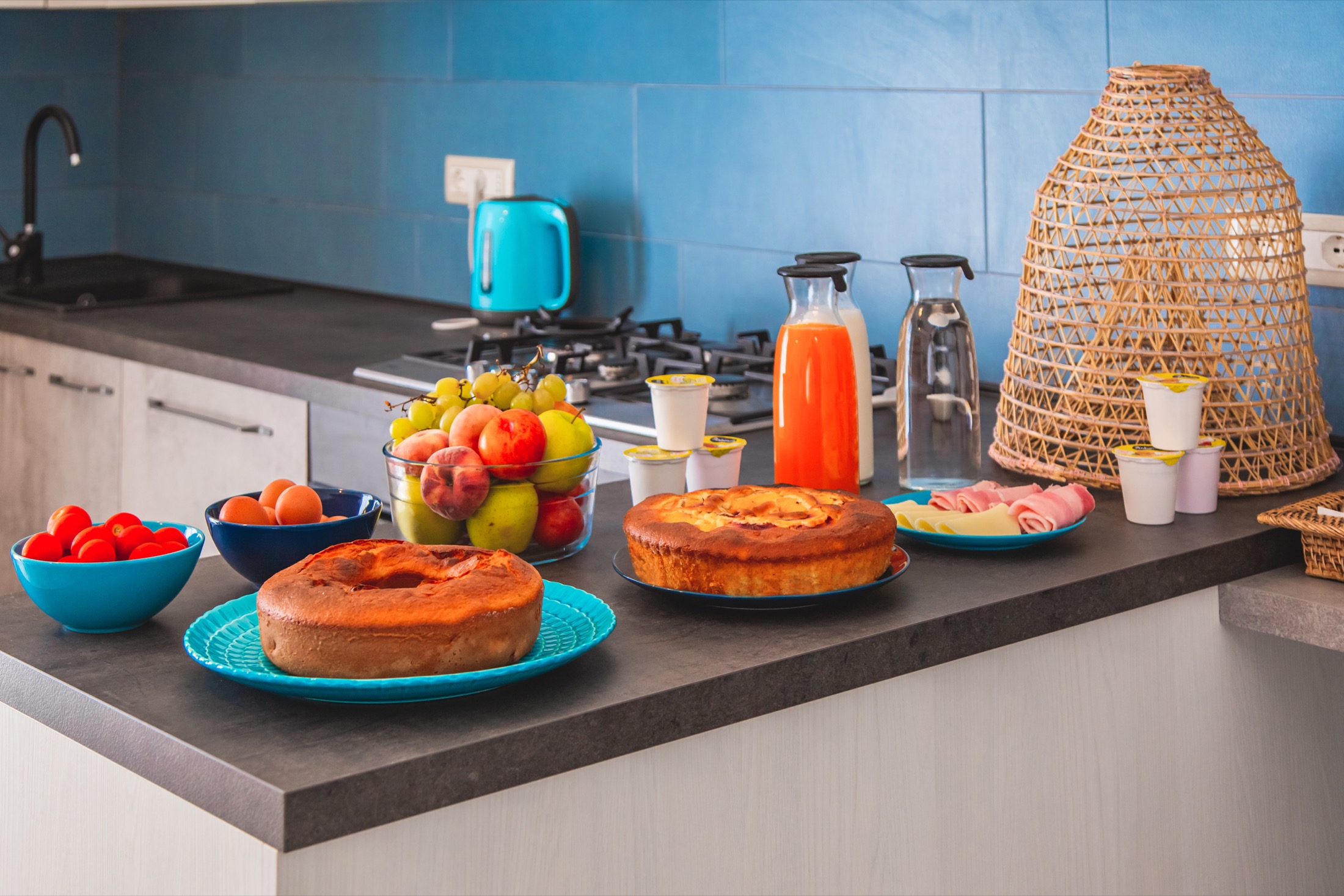 Tavola della colazione con torte fatte in casa, frutta fresca, yogurt e succhi